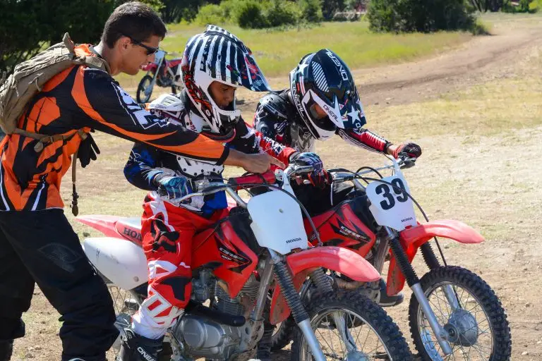 Coach instructing two Iron Horse Country Motocross Summer campers how to ride Honda CRF 80 100 125 150 dirt bikes