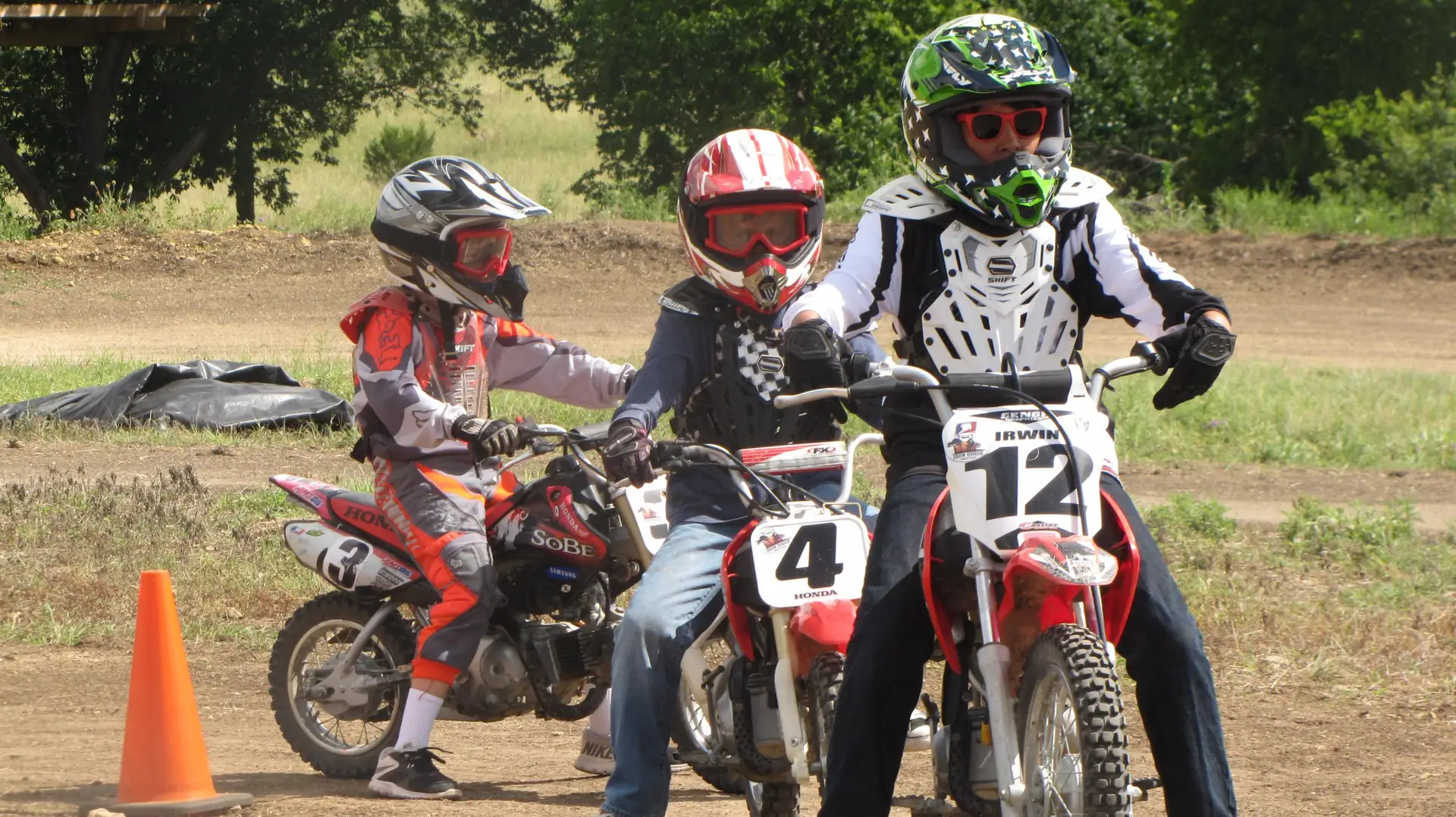 3 motocross summer camp riders on Honda motorcycles learning to ride at Iron Horse Country Ranch and showing what to wear