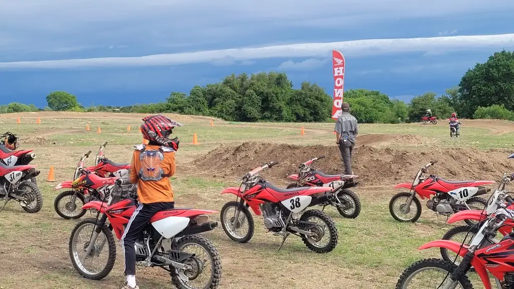 Summer Camp dirt bike rider looks back at friends and coach at Iron Horse Country motocross track horseshoe riders