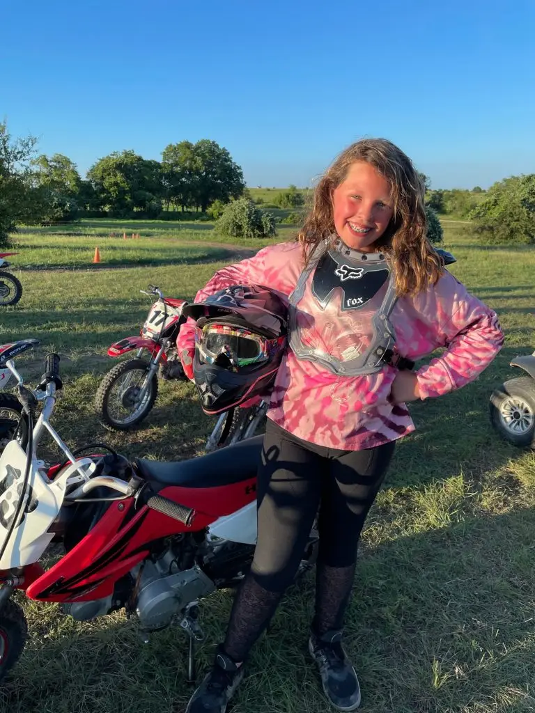 Girl in motocross gear with Honda motorcycle at Summer Camp at Iron Horse Country Ranch