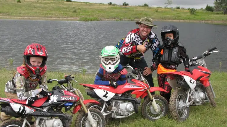 Learn to ride days at Iron Horse Country Summer Camp Coach with kids on Honda dirt bikes by pond