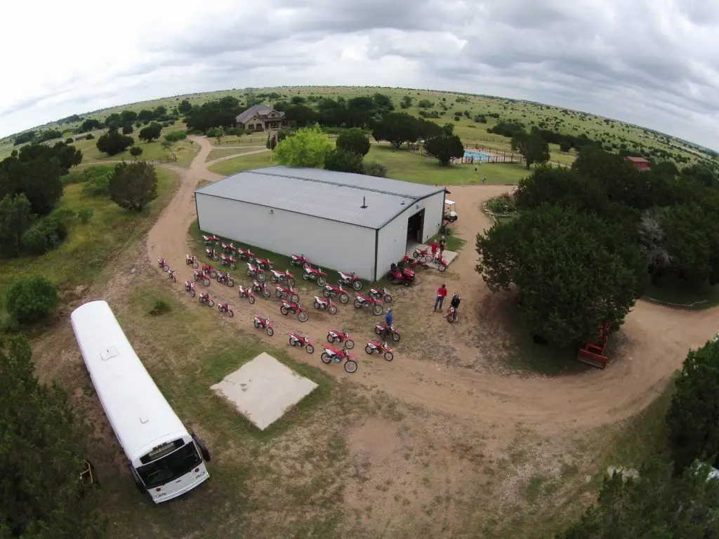 Recreation Center at Summer Camp at Iron Horse Country with riders lined up to ride near white bus