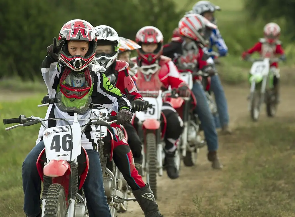 Summer camp riders outdoor activities at Iron Horse Country motocross summer camp Austin Texas in Burnet County